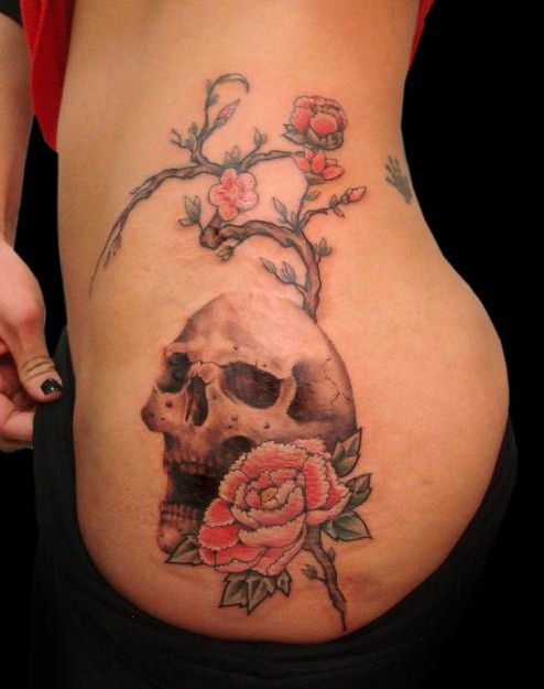 Rose and skull tattoo on the hip