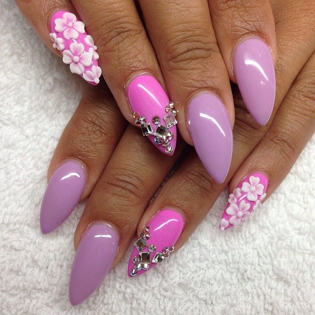 purple and pink stiletto with white flowers and jewels nail art .