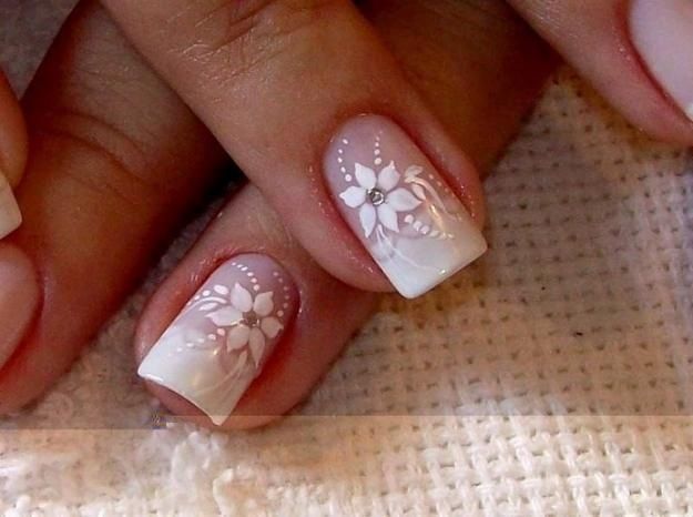 White floral/flower nail art with silver rhinestones on a french .