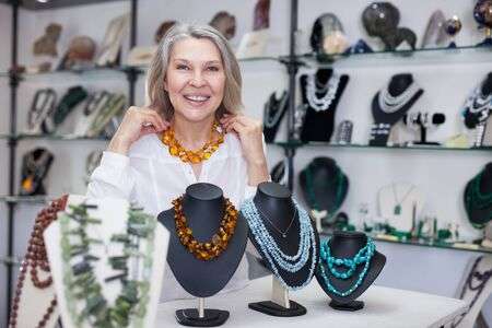 Adult Woman Chooses Jewelry From Turquoise And Amber Jewelery .