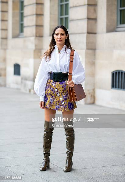 A guest is seen wearing overknees boots, white button shirt .